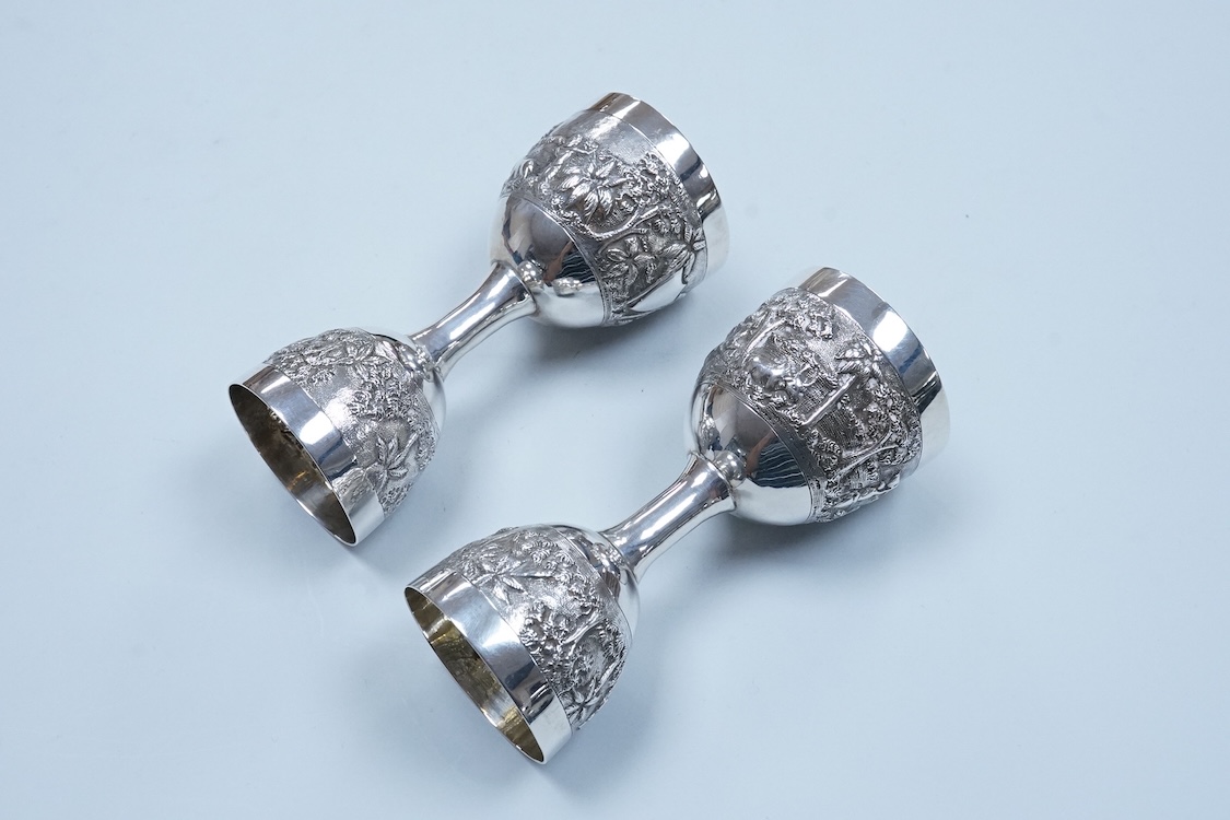 A pair of Indian embossed white metal single and double ended measures, 11.9cm, 5.2oz.